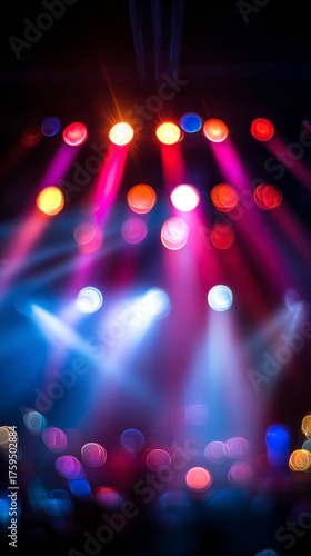 Vibrant stage lighting with beams of color shining through the concert crowd.