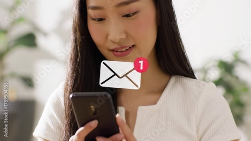 Extreme close-up video of a young asian woman with long dark hair and white top, smiling while tapping a smartphone with email notification against soft bokeh. Concept of seamless digital