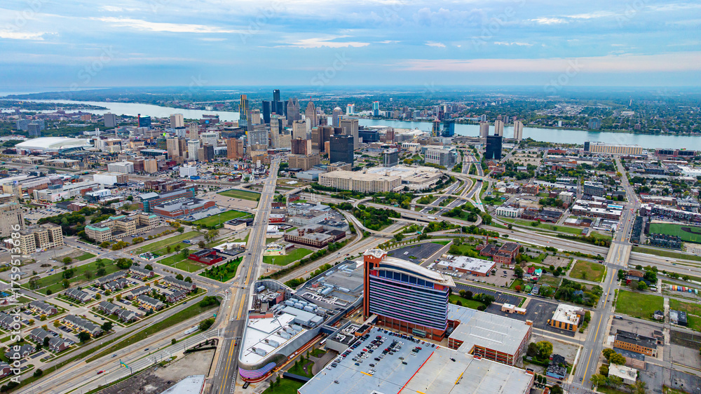 Obraz premium Detroit city skyline aerial view with highways and river. Aerial view of Detroit skyline with highways, skyscrapers, and the Detroit River in the distance.