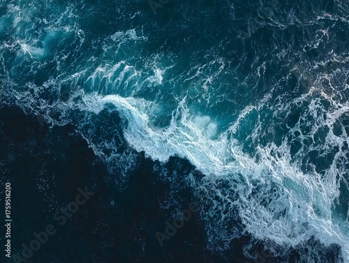 Aerial View of Turbulent Ocean Waves with Foamy White Crests Against Deep Blue Waters