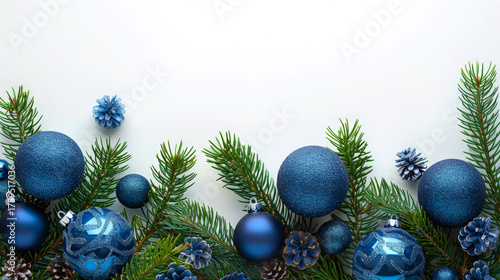 Blue Christmas balls and green fir tree branches arranged on white background. Mockup for winter holiday designs, greeting cards, festive banners. Copy space.
