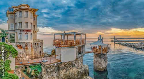Coucher de soleil en bord de mer avec le restaurant atypique du plongeoir à Nice dans la baie des anges sur la Côte d'Azur