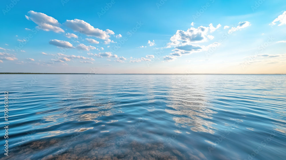 Obraz premium Calm lake reflecting clouds under blue sky creates serene atmosphere