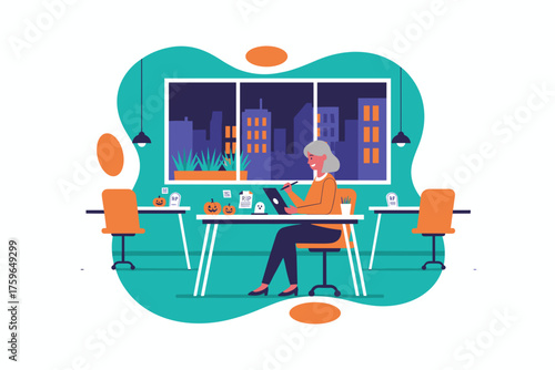 Senior woman designer creates digital art on tablet in Halloweendecorated office at night