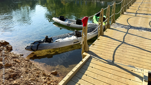 Photos Tranquil kayaks adrift beneath sunlit wooden bridge, echoing serene escape for W