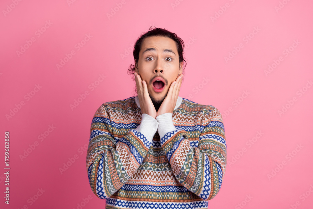Φωτογραφία Portrait of a surprised man wearing a colorful sweater holding his face with ast