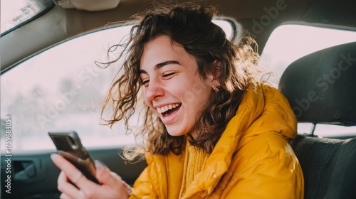 Happy woman using phone laughing inside car on road trip