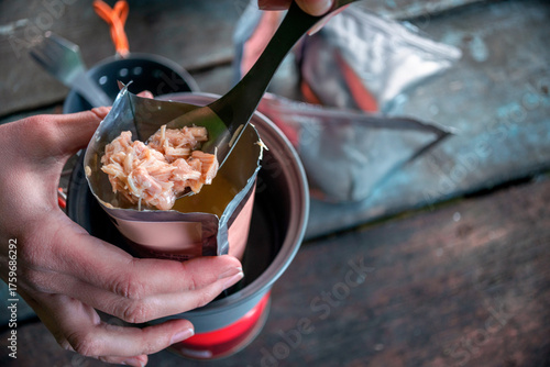 Close-up of camper preparing freeze-dried meal outdoors, showcasing authentic backpacking food and adventure lifestyle
