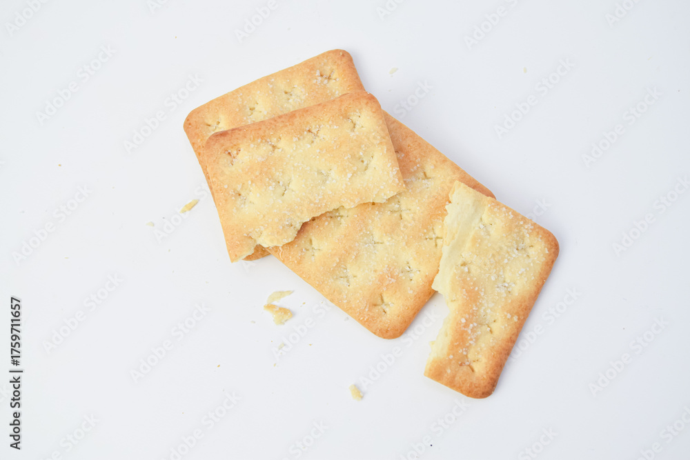 Fototapeta premium Broken crackers with crumbs on white background, top view minimal food photo showing crispy texture, simple composition suitable for snack, bakery, or diet concept.