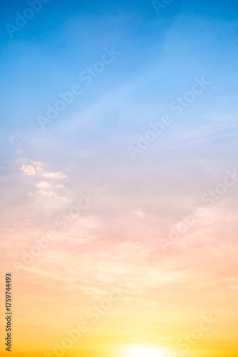 Sunset or sunrise sky with a vibrant gradient of orange, gold, and soft blue. Clear atmosphere with wispy clouds. Peaceful, natural light background. hope, freedom, new day Concepts, Vertical