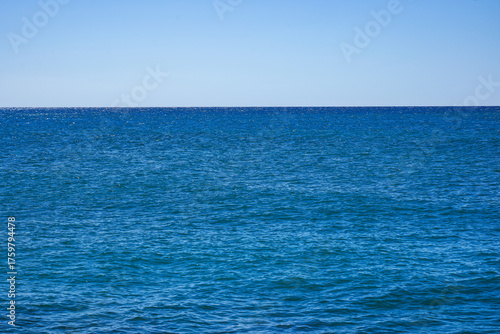 Expansive Azure Ocean Under a Clear Sky, Showcasing Tranquil Waters and Endless Horizon as Daylight Illuminates the Serene Coastal View
