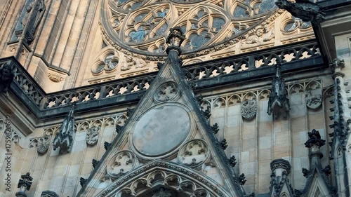 Monumental Gothic St. Vitus Cathedral dominates the Prague Castle complex under a bright blue sky. Iconic landmark and tourist destination in the Czech Republic.