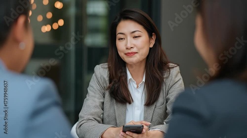 Smiling Asian Financial Advisor Engages Clients in a Professional Business Meeting, Offering Expert Advice and Solutions