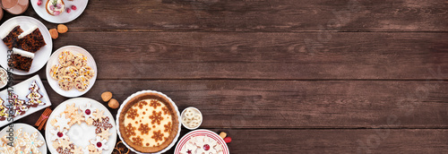 Obraz  z motywem Christmas holiday cookies and desserts corner border. Top view on a dark wood banner background. Eggnog pie, an assortment of cookies, fruit cake, cupcakes and chocolate eggnog. Copy space.