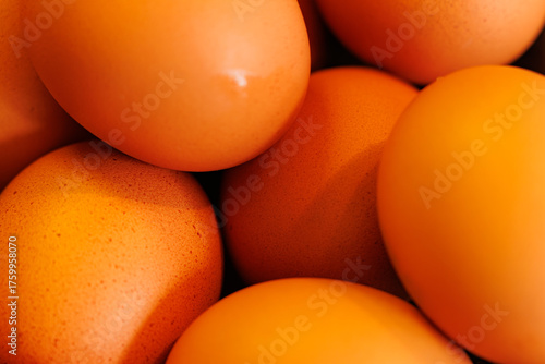 Fresh orange eggs fill a wooden basket, ready to be used for a delicious breakfast or baking delight.