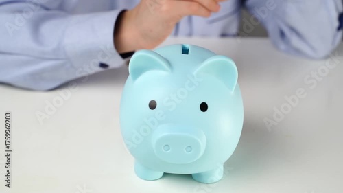 A boy collects coins in a piggy bank. Savings concept