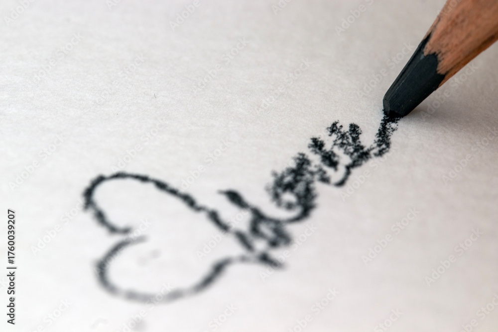 Fototapeta premium Scribbling with a pencil on white paper. Close-up. heart shape