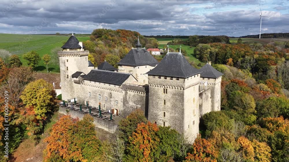 Vue aérienne du superbe château de Malbrouck, sur les hauteurs du village de Manderen en Moselle. Mi-octobre le feuillage des arbres est aux couleurs de l'automne et le ciel est très nuageux