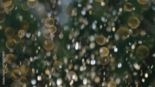 Animación de fondo abstracto de particulas brillantes callendo como lluvia y circulos bokeh fijos en primer plano.