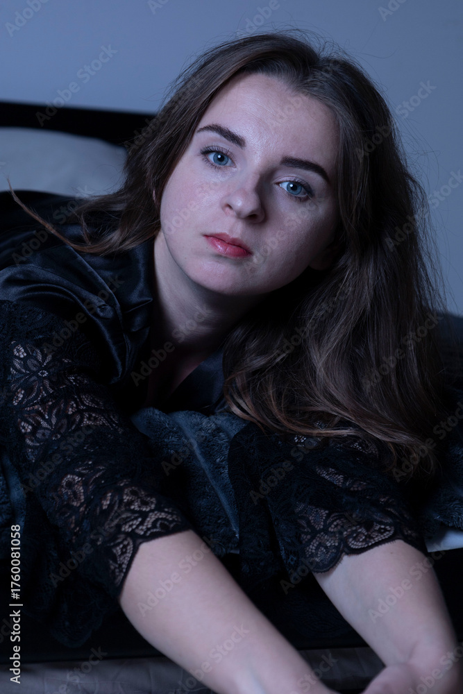 Fototapeta premium Woman wearing black lace robe relaxing on bed