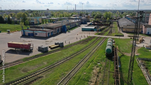 A railway line leading to a large oil refinery. Oil tanks on the railway tracks.