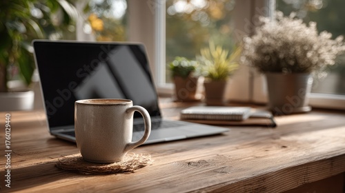 Cozy workspace with a laptop, coffee mug, notebooks, and potted plants on a wooden table near a sunny window for productive work and relaxing environment