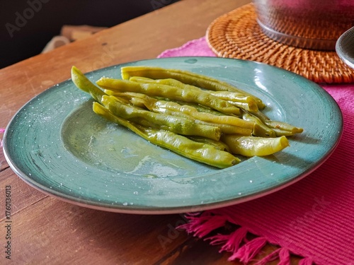 A round plate with fresh green beans, presented simply and elegantly, perfect for a healthy, colorful meal. The composition highlights the texture and natural shine of the vegetables, evoking freshnes