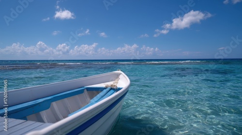 Fototapeta Naklejka Na Ścianę i Meble -  Small Motorboat Gliding Across Clear Water Under Bright Blue Sky on Serene Day