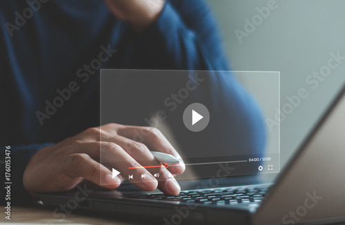 Businessman using laptop to play online video, showing digital media streaming interface and modern technology for video content, online learning or entertainment platform for marketing and education.
