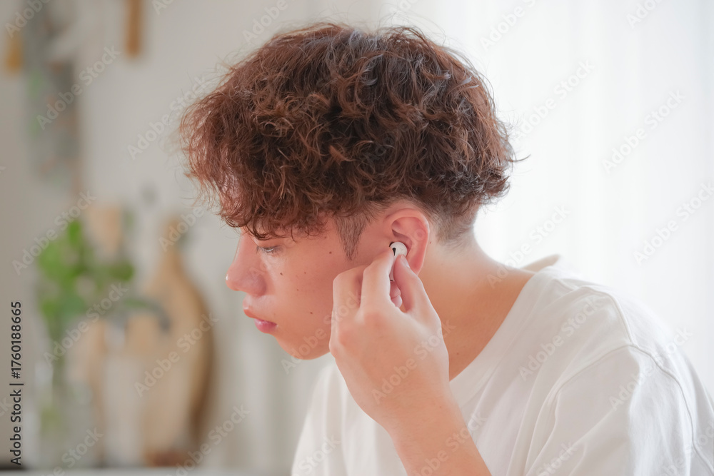 Fototapeta premium ワイヤレスイヤホンをつける若い男性