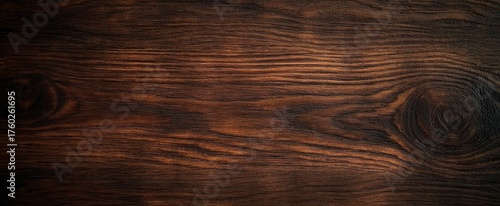 Close-up view of dark brown wooden surface with natural wood grain patterns and knots