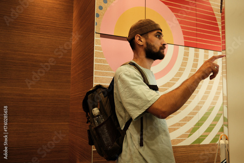 Fotografie Young man using a digital self-service kiosk to place an order in fast food restaurant