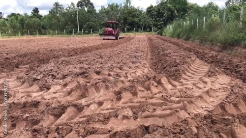 Preparing Farmland: A lone tractor meticulously prepares a vast field, carving neat rows into the rich soil in anticipation of the upcoming harvest.
