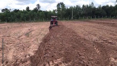 Plowing Field with Tractor: A tractor, engaged in the essential task of plowing the field, carving neat rows into the rich, brown earth in preparation for planting.