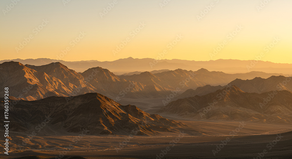 Naklejka premium Scenic Mountain Range Landscape at Sunset with Layers of Peaks and Warm Light