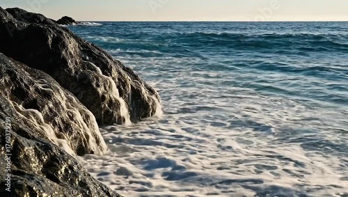 Surging Ocean Waves Crashing Against Rocky Shoreline at Sunrise