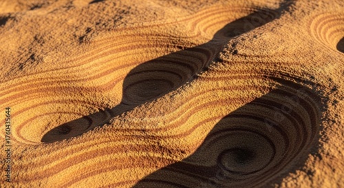 Sandstone surface with swirls, eroded texture, and striations in the warm light