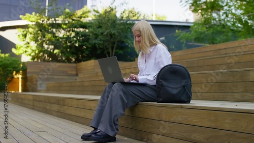 Young student working on laptop outdoors