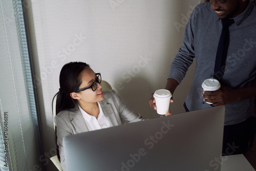 Canvas-taulu Young African American man bringing coffee to his Asian female colleague sitting