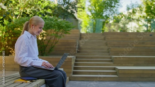 Woman on video call with laptop outdoors