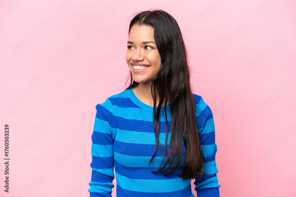 Fototapeta premium Young Colombian woman isolated on pink background looking side