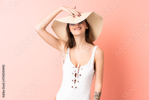 Young woman over isolated pink background happy in swimsuit in summer holidays