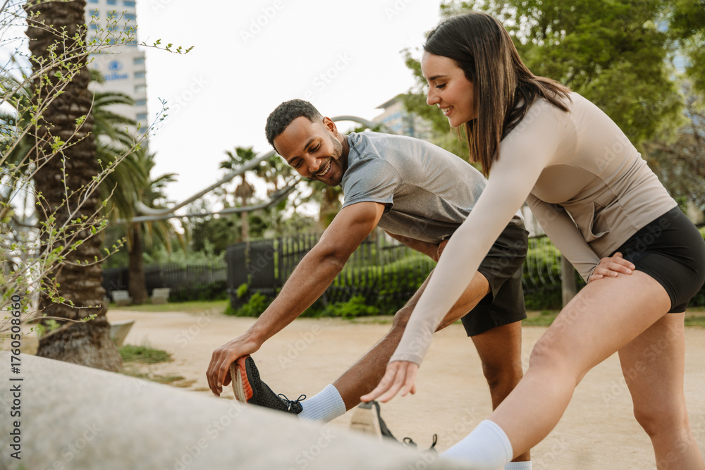 Obraz premium Male and female athletes are smiling and stretching their hands to their feet