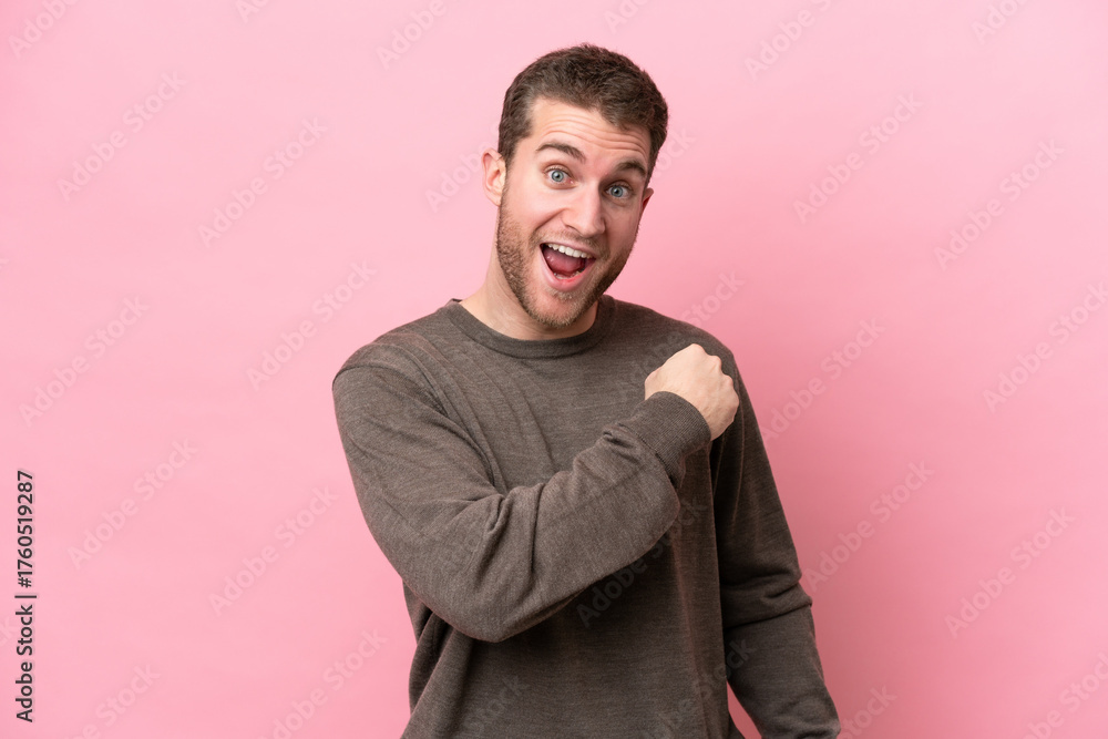 Obraz premium Young caucasian man isolated on pink background celebrating a victory