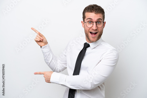 Young business caucasian man isolated on white background surprised and pointing side