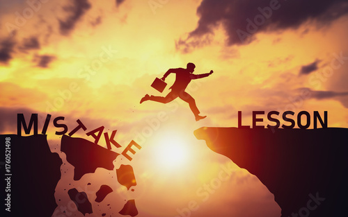 Cuadro en lienzo Silhouette of businessman jumping over cliff from word Mistake to Lesson
