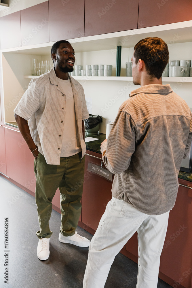 Obraz premium A male worker is smiling and talking to a male worker standing across from him
