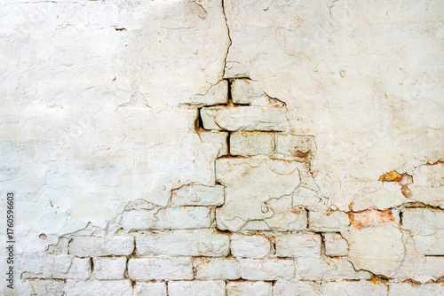 Aged brick wall surface showing cracks, decay, and weathered damage.