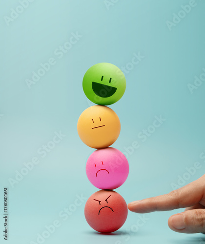 Hand balancing Colorful emotional faces Ball, symbolizing mental health and emotional