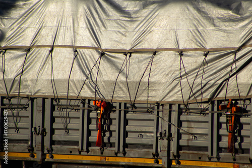 Close-Up of Truck Tarpaulin, Ropes, and Cargo Straps in Shadow